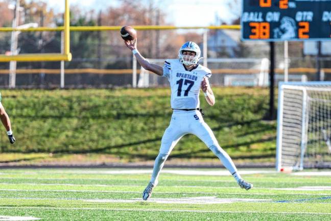 <b>Rolling to his left, junior quarterback Shane Hoover releases a pass late in the first half against Montville. (Photo by Glenn Clark)</b>