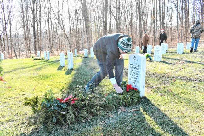 A volunteer places a wreath on a grave Saturday, Dec. 14 at the Northern New Jersey Veterans Memorial Cemetery in Sparta. (Photo by Maria Kovic)