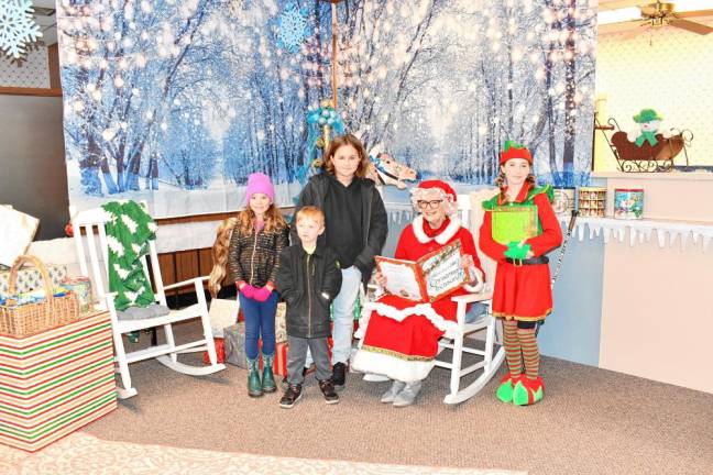 Madeline Celentano of Blairstown and Colton and Abel Corbisiero of Stillwater pose with Mrs. Claus and an elf.