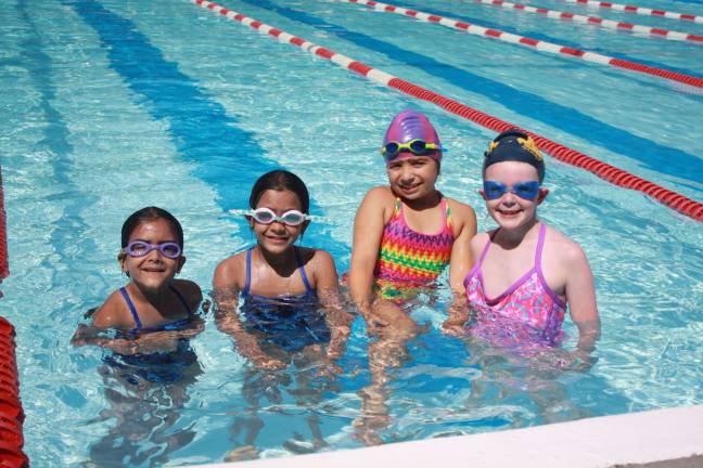 Mila Saluja, age 6, Yana Saluja, age 8, Noel Guerrini, age 7 and Brooke Shust, age 7 take a break for a photo in-between laps.