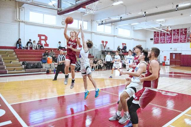 Newton’s Nick Kurilko raises the ball during a shot in the first half. He scored 15 points.