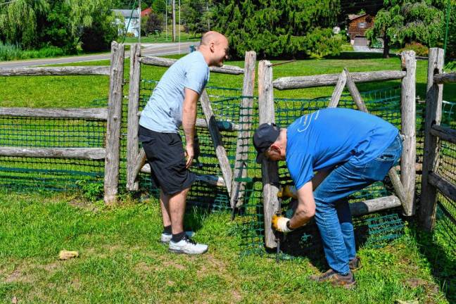 <b>Jason Bailey and Mark Stoller, volunteers from Selective Insurance, fix a gate at Rebecca’s Homestead in Branchville. (Photos by Maria Kovic)</b>