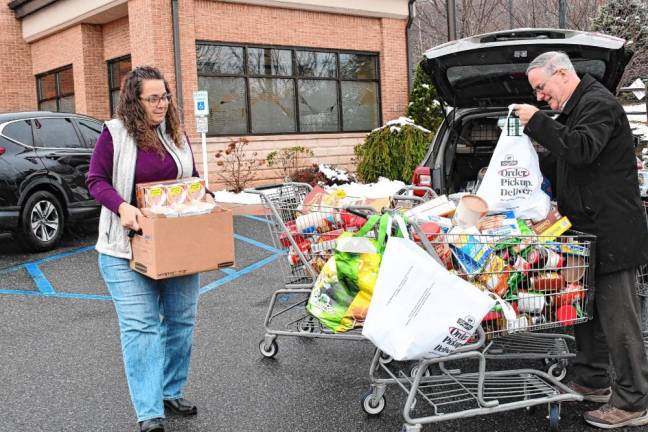 Diona Canal of Provident Bank carries food donated at the bank’s branches in Wantage, Vernon and Montague.