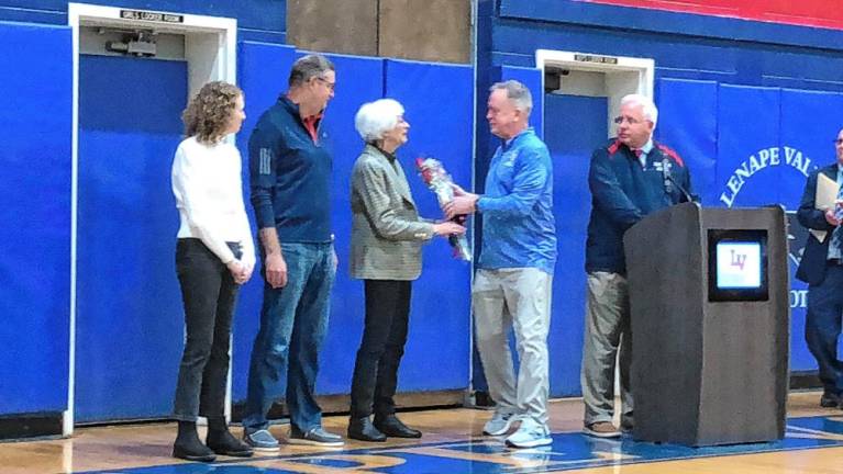 Flowers are presented to Judy Poetsch, widow of former Lenape Valley basketball coach Robert Poetsch, at a ceremony to name the basketball court for him.