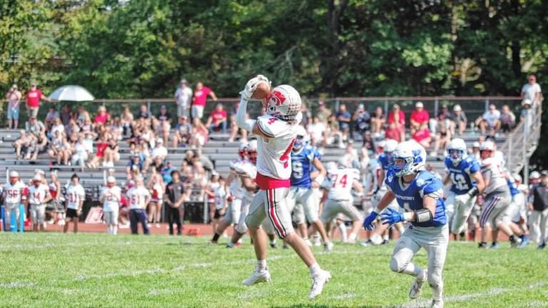 <b>High Point wideout Caden Nardone catches the ball while shadowed by Kittatinny defensive back Niko Martinez in the second half. The Wildcats defeated the Cougars, 36-21, in their third win in a row. (Photo by George Leroy Hunter)</b>