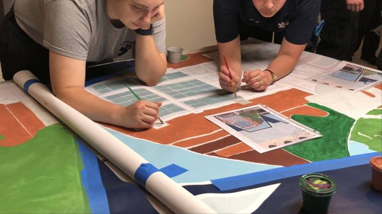 Kelly Ellsworth, left, and Lauren Hennighan at work on mural.